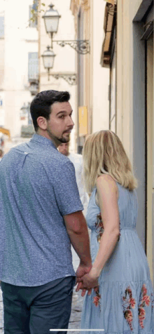 a man and a woman are holding hands on a street