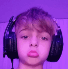 a young boy wearing headphones with a pink lip