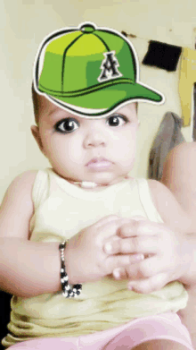 a baby wearing a green baseball cap with the letter a on it