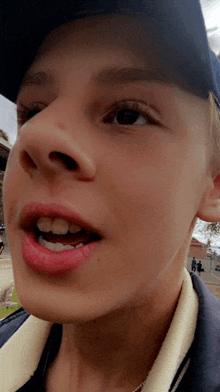 a close up of a boy 's face with a hat on