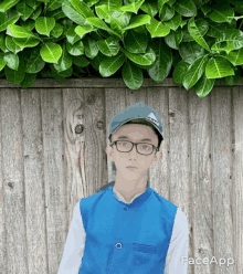 a boy wearing glasses and a hat stands in front of a wooden wall