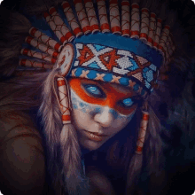 a woman with blue eyes is wearing a headdress with the letter x on it