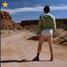 a man in white underwear stands on a dirt road with a yellow star above him