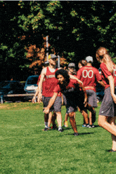 a group of people are playing a game of soccer and one of the players has the number 00 on his shirt