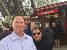 a man and a woman stand in front of a restaurant called restaurant 58