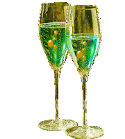 two wine glasses filled with green liquid and gold bubbles