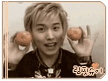 a young man is holding two oranges in front of his face