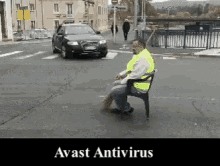 a man in a yellow vest is sitting on a bench in front of a car that says avast antivirus on it