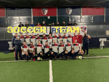 a group of soccer players pose for a photo in front of a sign that says " soccer team "