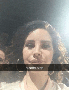 a woman wearing hoop earrings takes a selfie with a caption that reads please stop