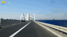 a car is driving on a highway with a bridge in the distance