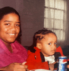 a can of pepsi sits next to a woman and a child