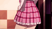 a girl in a pink plaid skirt is standing in front of a wall