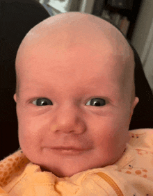 a close up of a baby 's face with a shaved head