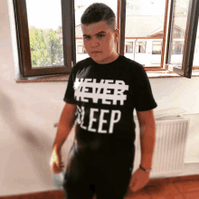 a boy wearing a shirt that says " never sleep "