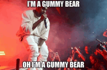 a man singing into a microphone with the words i 'm a gummy bear on the bottom