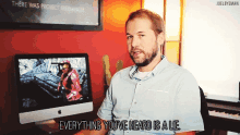 a man sitting in front of a computer with the words " everything you 've heard is a lie " below him