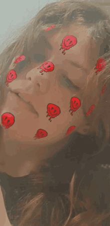 a close up of a woman 's face with red dripping smiley faces on it