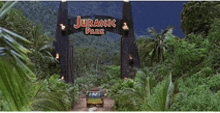 a car is driving through a jurassic park gate