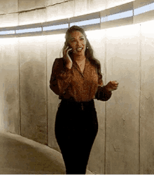 a woman is talking on a cell phone while standing in a tunnel .