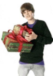 a young man in a black sweater is holding a bunch of gifts .