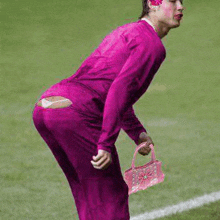 a man in a pink outfit is holding a pink basket