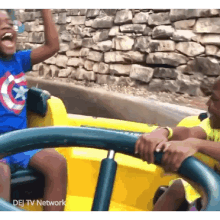 a boy wearing a captain america shirt is on a roller coaster