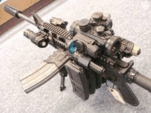 a rifle with a lot of accessories on it is sitting on a carpet .