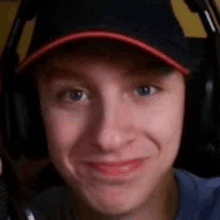 a close up of a person wearing headphones and a baseball cap .