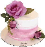 a pink and white cake that says annie cake shop