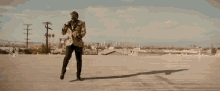 a man is dancing on a rooftop in front of a city .