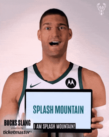 a man in a bucks jersey holds up a sign that says splash mountain