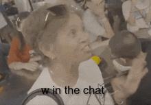 a woman sitting at a table with the words " w in the chat " on the bottom