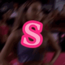 a pink letter s is in the middle of a blurry picture