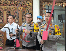 a man in a polri uniform holds a red ribbon