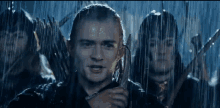 a group of people are standing in the rain holding spears