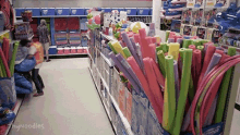 a store aisle filled with lots of colorful foam noodles .