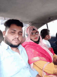 a man and a woman are sitting in the back of a car