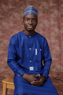 a young man wearing a blue polka dot shirt and hat