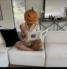 a woman with a pumpkin head is reading a book