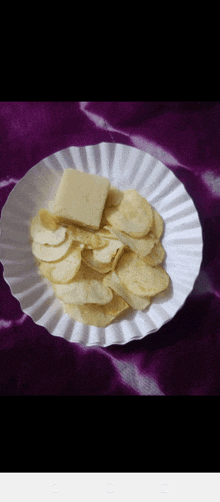 a paper plate with potato chips and cheese on it