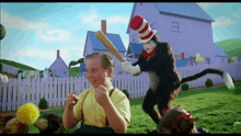 a cat in the hat is swinging a bat at a little boy