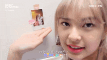 a girl is holding up a polaroid picture with baby monster written on the bottom right