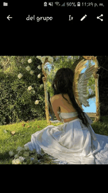 a phone screen shows a picture of a woman with angel wings