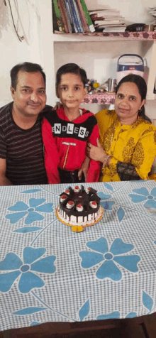 a family posing for a picture in front of a birthday cake