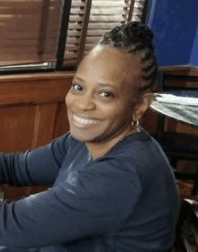 a woman with braids in her hair is smiling for the camera