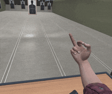 a person 's hand is pointing at a target in a shooting range