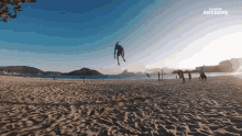 a man is jumping over a volleyball net on a beach with the words " awesome " on the bottom