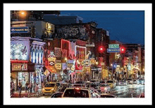 a picture of a busy city street at night with a lot of cars .