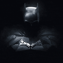 a black and white photo of a batman with the word justice written on the chest